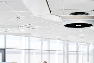 Moderne kontor med ophængt rund LED loftlampe, lys design i arbejdsområde.
