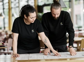 Coor medarbejdere der kigger på plantegning for en bygning