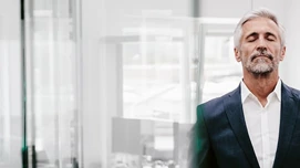 Mandlig medarbejder der tager sig tid til afstressende åndedræt