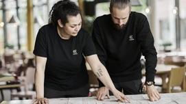 To medarbejdere der kigger på plantegninger for en ejendom
