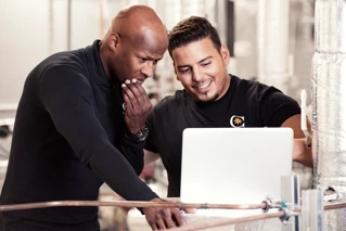 To driftsmedarbejdere der kigger på data på en arbejdscomputer