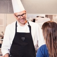 En mandelig kok der smiler til en Coor kollega der bestiller mad
