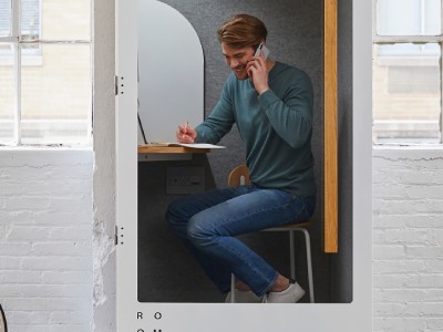 Man speaking in his phone in a work booth | Coor