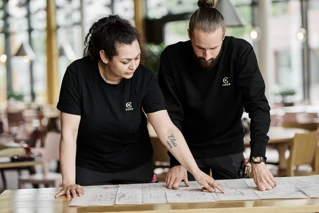 Driftsmedarbejdere der diskuterer plantegningen for en lokation