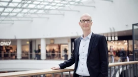 Mand i forretningsdragt står ved rækværk i Bruubs galleri