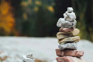 Stenbalance i natur med farverige stenstak på en uklar baggrund.