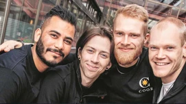 Medarbejder der holder om hinanden i et kram og smiler