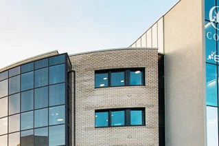 A building with blue glass, and a blue background on a sunny day.