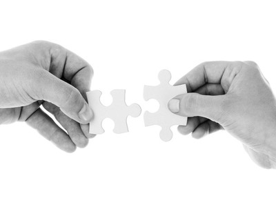 Hænder forbinder puslespil, der viser venskabet på arbejdspladsen | Coor