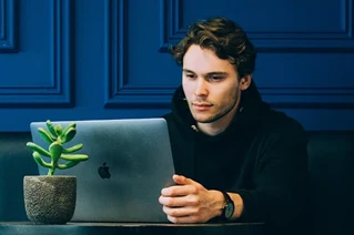Mand der kigger på sin macbook