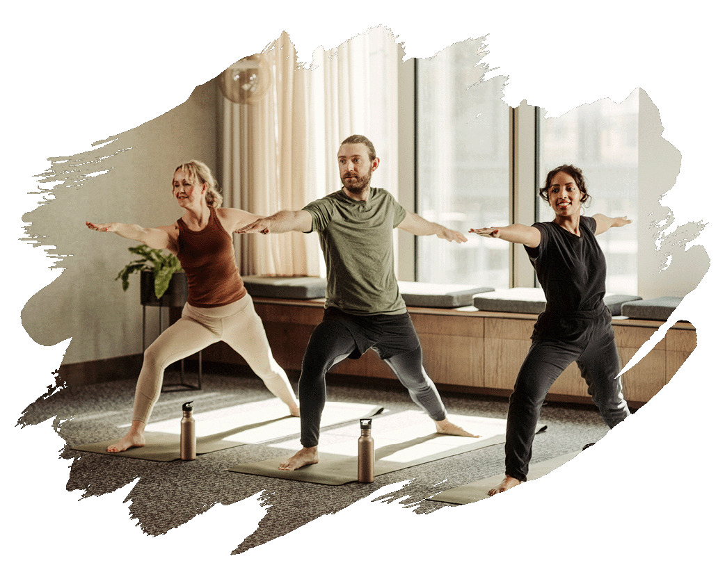 to kvinder og en mænd der dyrker yoga