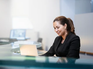 Kvindelig medarbejder, sidder og arbejder på computer