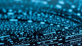 Blåt lys der reflekterer i vanddråber på en glat overflade, mulig anvendelse i teknologi og natur baggrunde.